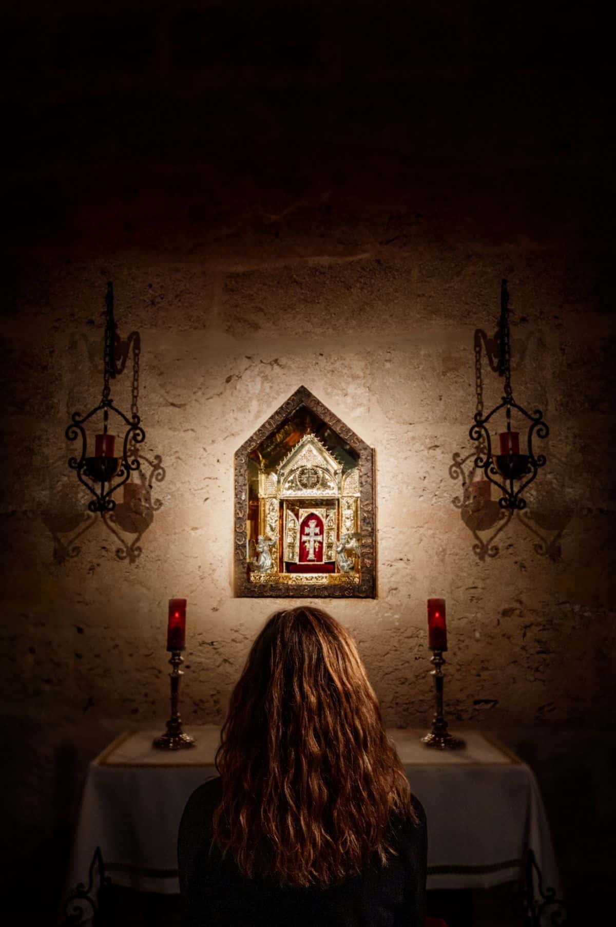 Una mujer rezando ante el lignum crucis. 