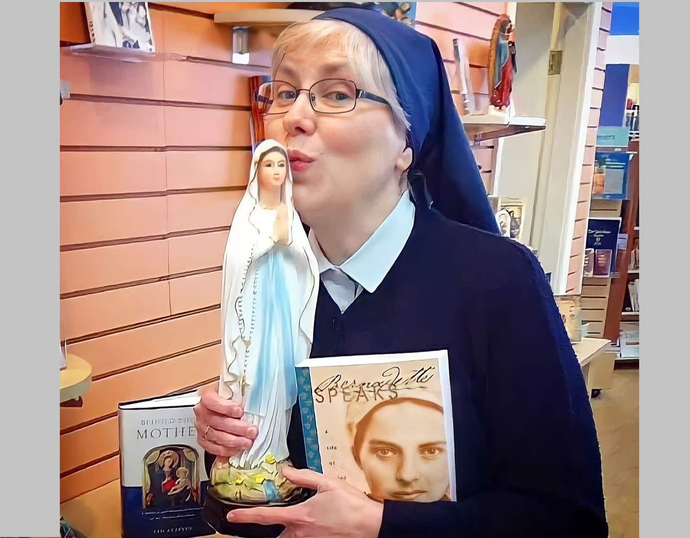 La hermana Julia Mary con una imagen de la Virgen de Lourdes y de La Canción de Bernadette en su librería de las paulinas
