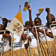 Unos niños africanos portan banderas del Vaticano