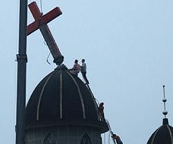 Unos operarios y una grúa retiran una cruz de una iglesia de Wenzhou por orden gubernamental