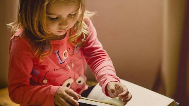 Una niña leyendo.