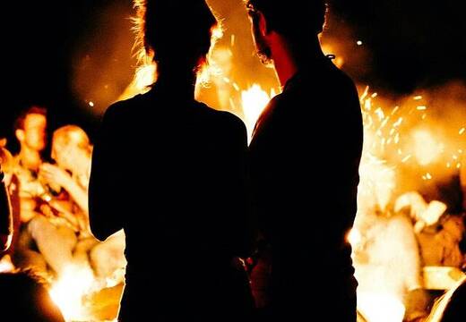 Dos personas silueteadas junto a una hoguera de noche, foto de Wesley Balten en Unsplash