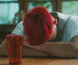 Un joven de pelo rojo, hundido, quizá deprimido... foto por Jose Pena en Unsplash