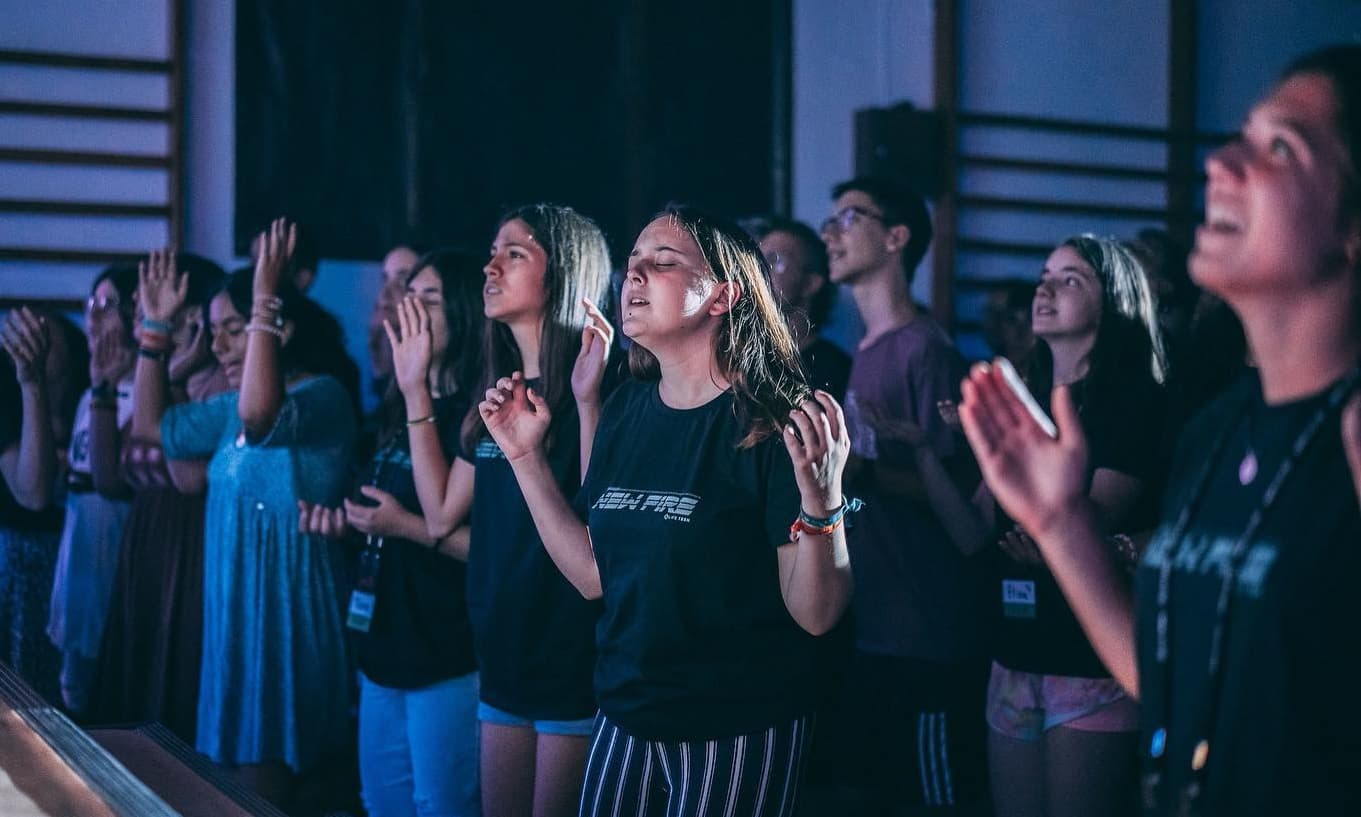 Adolescentes entregados en adoración y alabanza en el campamento de verano de LifeTeen
