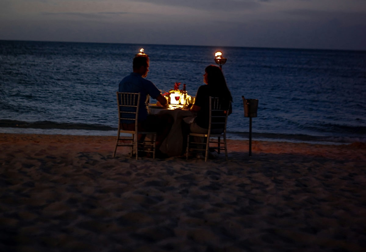 Una pareja de cena romántica en la playa, foto de Zack Marshall en Unsplash