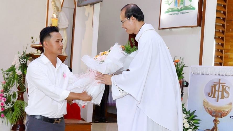 Ho entrega un ramo de flores al padre Juan de la Cruz Hoang Quang Hai, de la parroquia de Dong Ha.