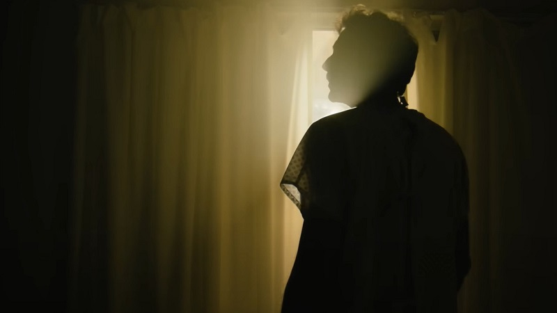 Una escena del documental Después de la Muerte, un hombre se levanta desconcertado, entre luz y sombras