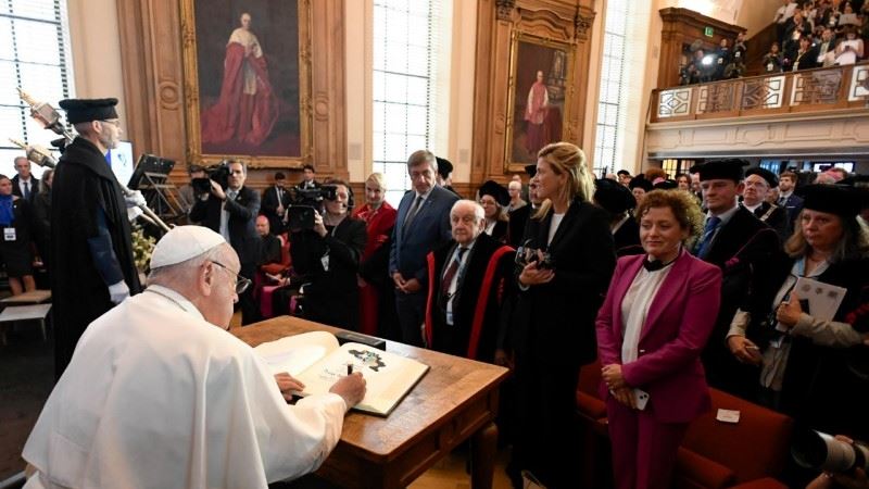 Francisco firma en el libro de honor de la universidad.