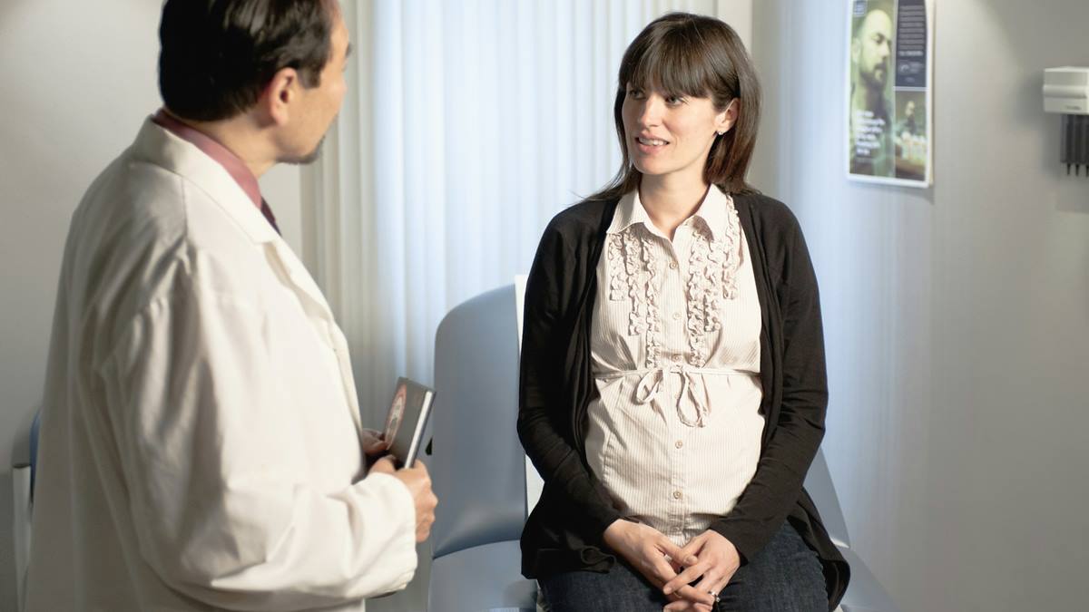 Una mujer embarazada junto a su médico.