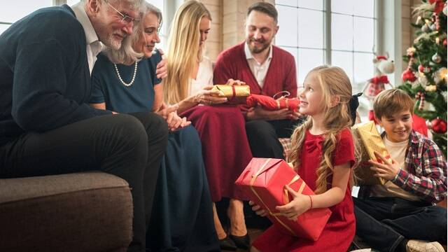 Abuelos, padres y niños, juntos y alegres en las fiestas de Navidad, con el árbol, foto de Freepik