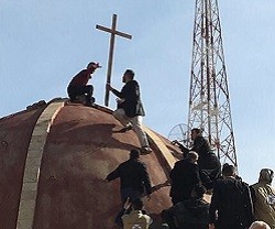 Varios cristianos vuelven a colocar la cruz en la cúpula de la iglesia