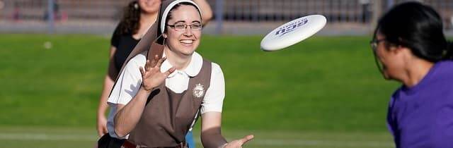 Monja jugando al frisbi en la universidad