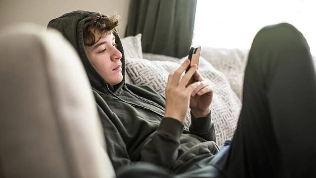 Adolescente viendo su teléfono móvil