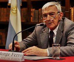 Jorge Ferro, durante una conferencia, con la bandera argentina de fondo.