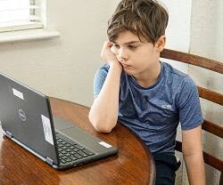Un niño mirando un ordenador. 