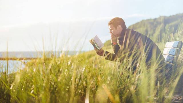 Un hombre leyendo en el campo.