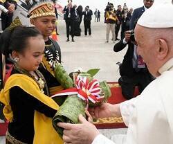 Unos niños con trajes típicos indonesios entregan flores al Papa Francisco a su llegada al aeropuerto de Yakarta