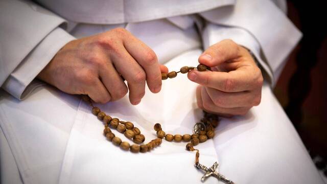 Una monja rezando el rosario. 