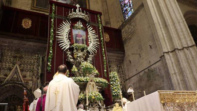 Los oficiantes de la misa de beatificación rezan al nuevo beato, representado en un cuadro del pintor Raúl Berzosa. Foto: Archidiócesis de Sevilla.