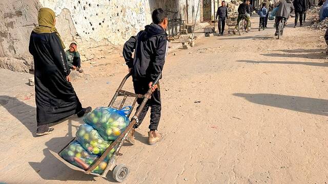 Vecinos de la parroquia de Gaza llevan su lote de frutas y verduras que reparte el Patriarcado y la Orden de Malta