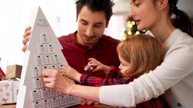 Una familia preparando el calendario de Adviento.  