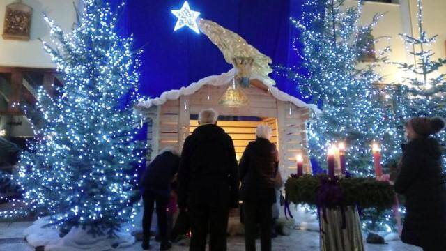 Un matrimonio viendo un belén de Navidad.