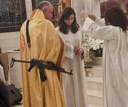 Sacerdote con metralleta en misa... no es un montaje pero se ha sacado de contexto 