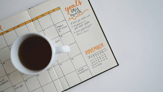 Una taza de café sobre un calendario.